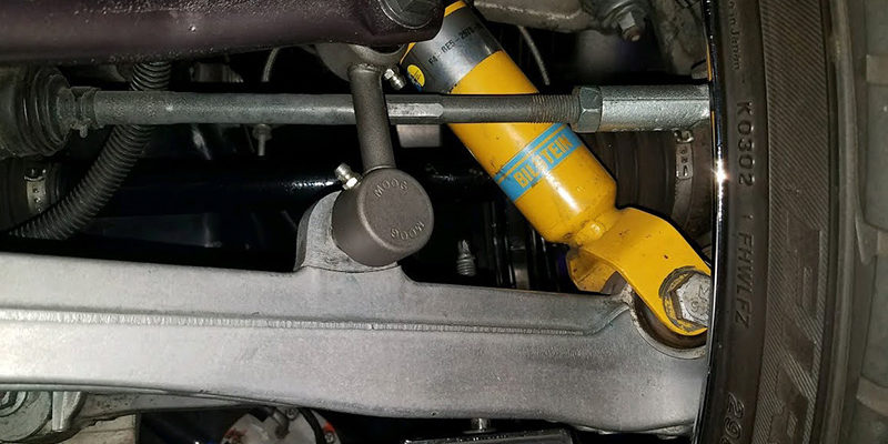 An image of a car part next to the car tire